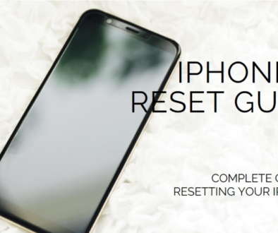 A black smartphone lying on a surface covered with white petals, displaying the text “IPHONE 11 RESET GUIDE"