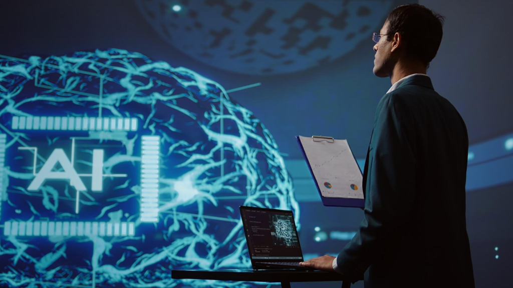 A person in a suit holding a clipboard stands in front of a laptop on a desk with an intricate digital brain graphic in the background illuminated in blue representing AI development services